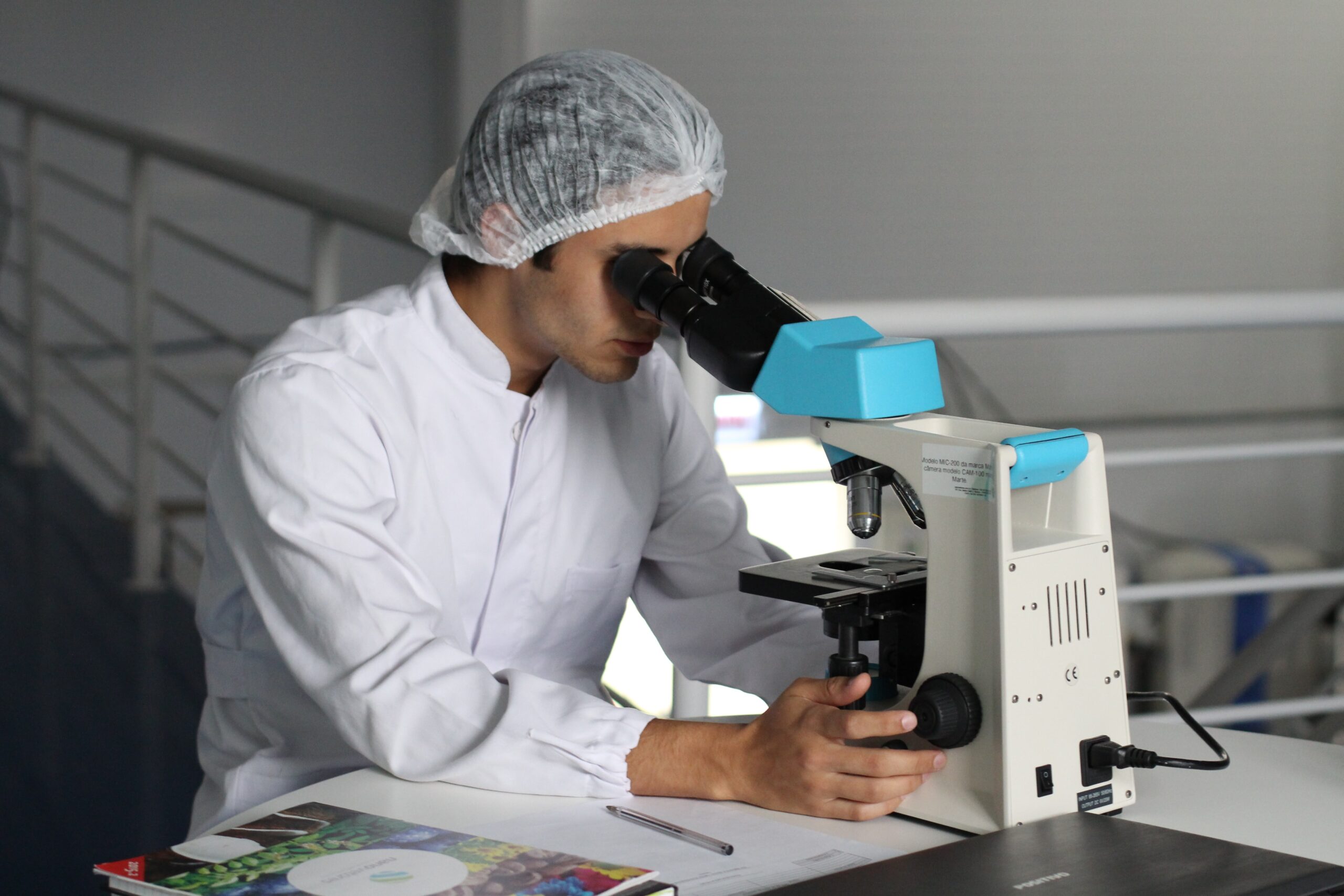 mężczyzna patrzący w mikroskop w laboratorium